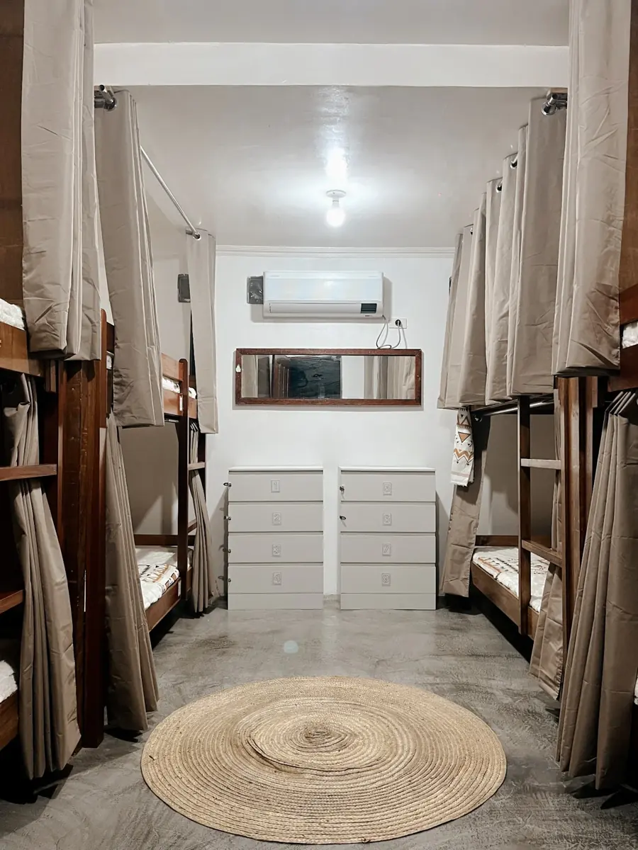 Mixed dorm with curtained bunk beds and individual storage