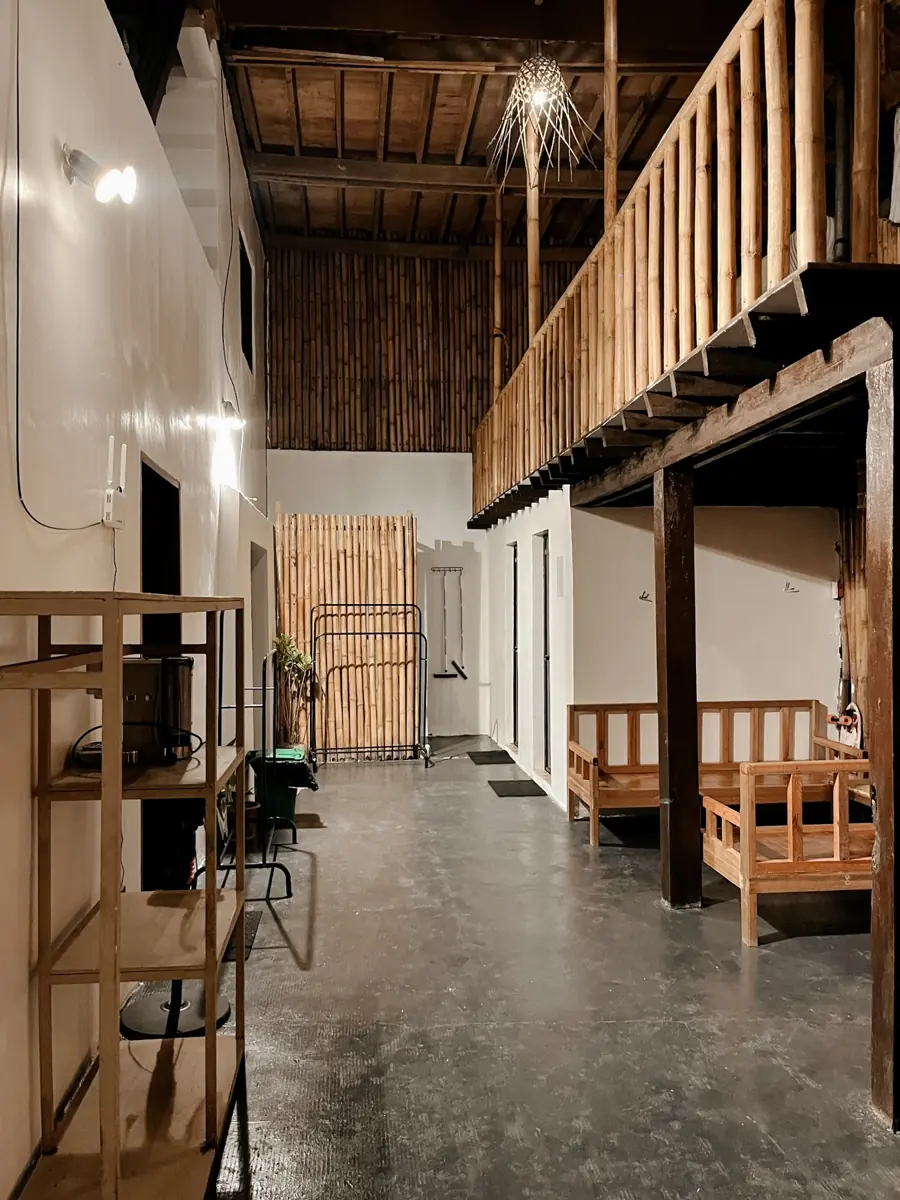 The Eight Siargao shared space with wooden seating and an upstairs balcony